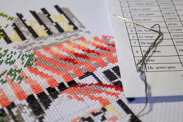 A floss color key next to a piece of stitching in progress